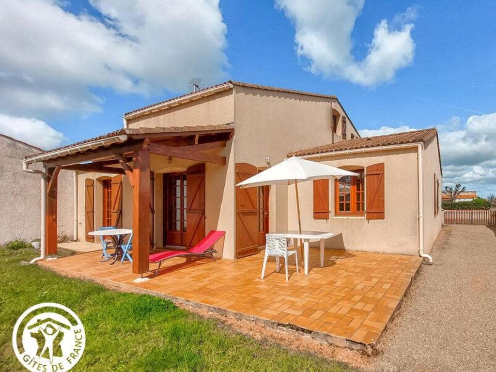 Casa con patio con mesa y sombrilla en Charmant gîte 6 pers. à Jard-sur-Mer, proche plage et Vélodyssée - FR-1-426-568, en Jard-sur-Mer