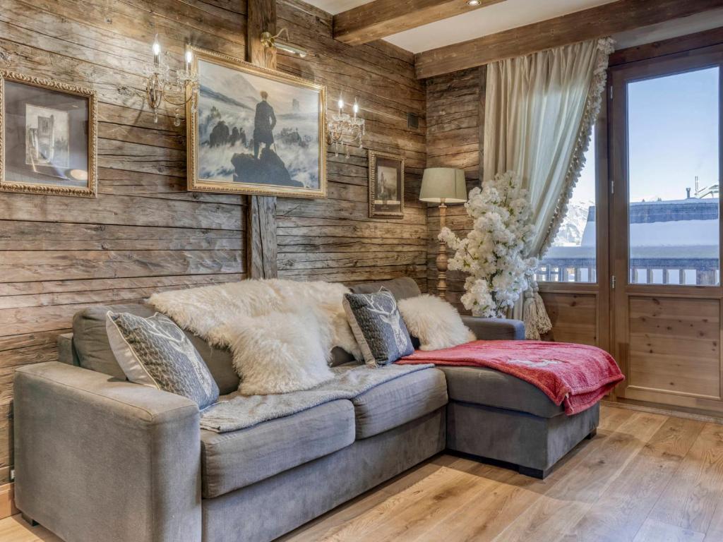 - un salon avec un canapé et des murs en bois dans l'établissement Appartement centre Megève - 2 pièces, Animaux admis, Wifi - FR-1-453-324, à Megève