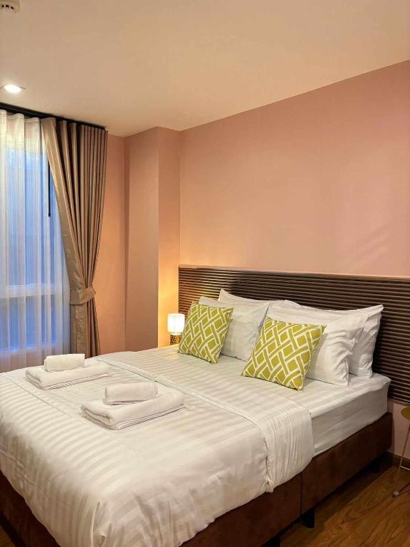 a bedroom with a large bed with two pillows at Comfy family room hatyai in Ban Khlong Pleo