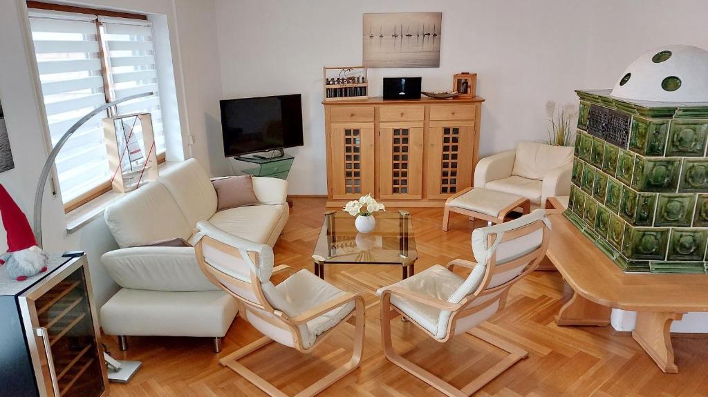 a living room with chairs and a table and a tv at Chiemsee-Ferienhaus Schlegel in Breitbrunn