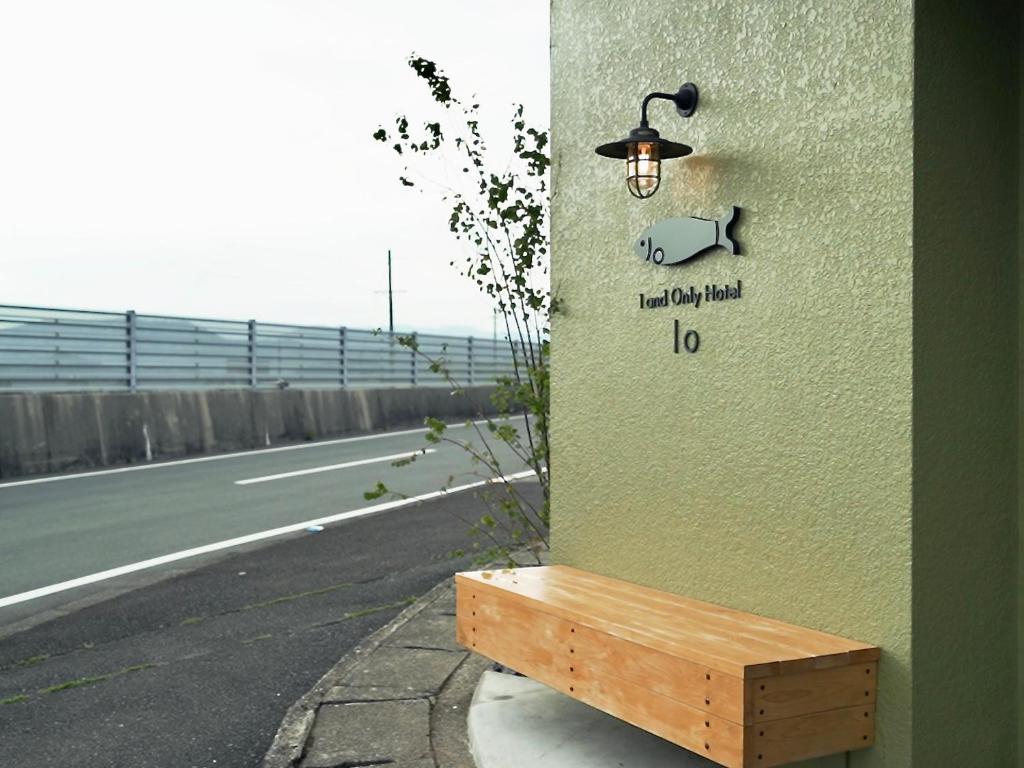 a light on the side of a building with a bench at 1 and Only Hotel Io - イオ in Minamiise