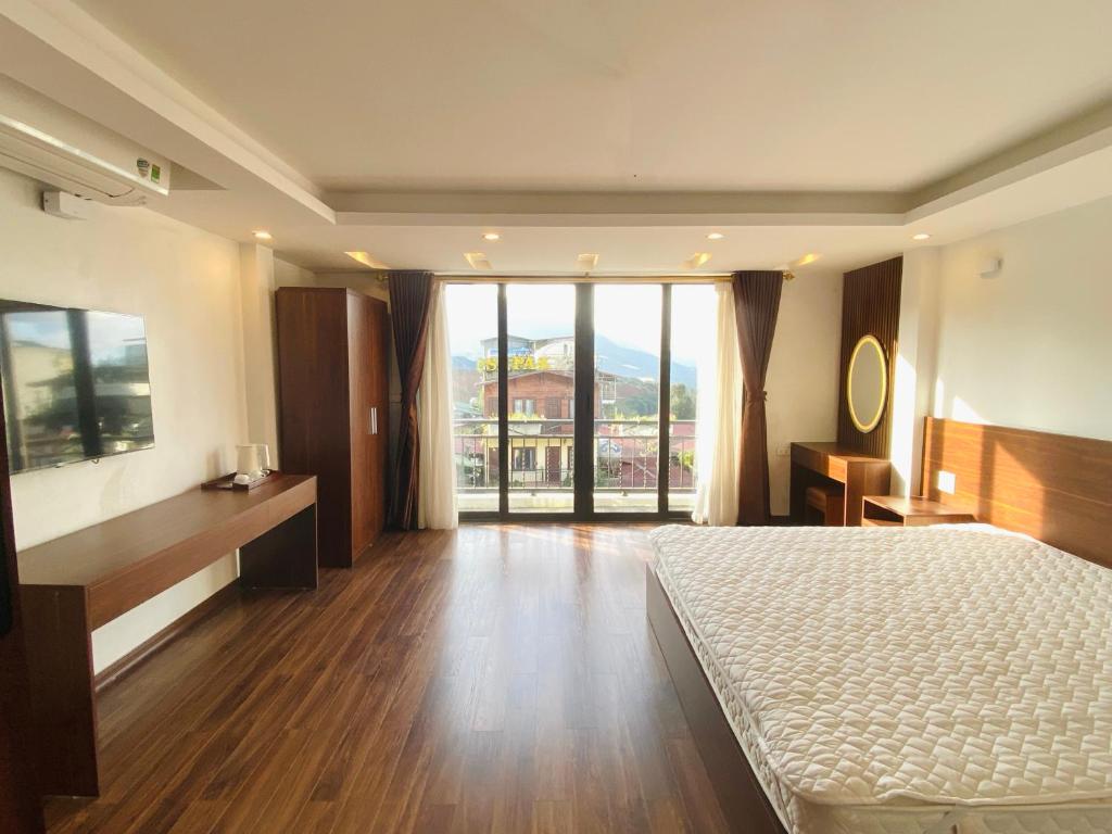 Un dormitorio con una cama y una ventana grande. en Homestay Sapa, en Sa Pa