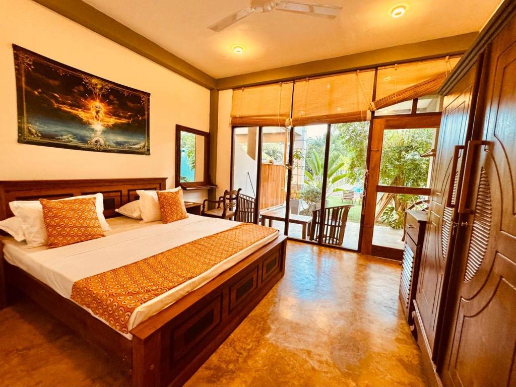 Un dormitorio con una cama y un televisor en una habitación. en Dharma Place, en Ahangama