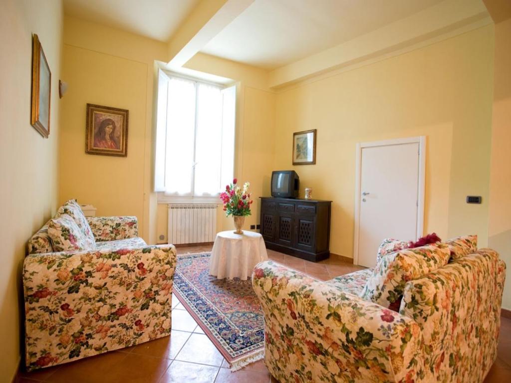 a living room with two chairs and a tv at San Firenze in Florence