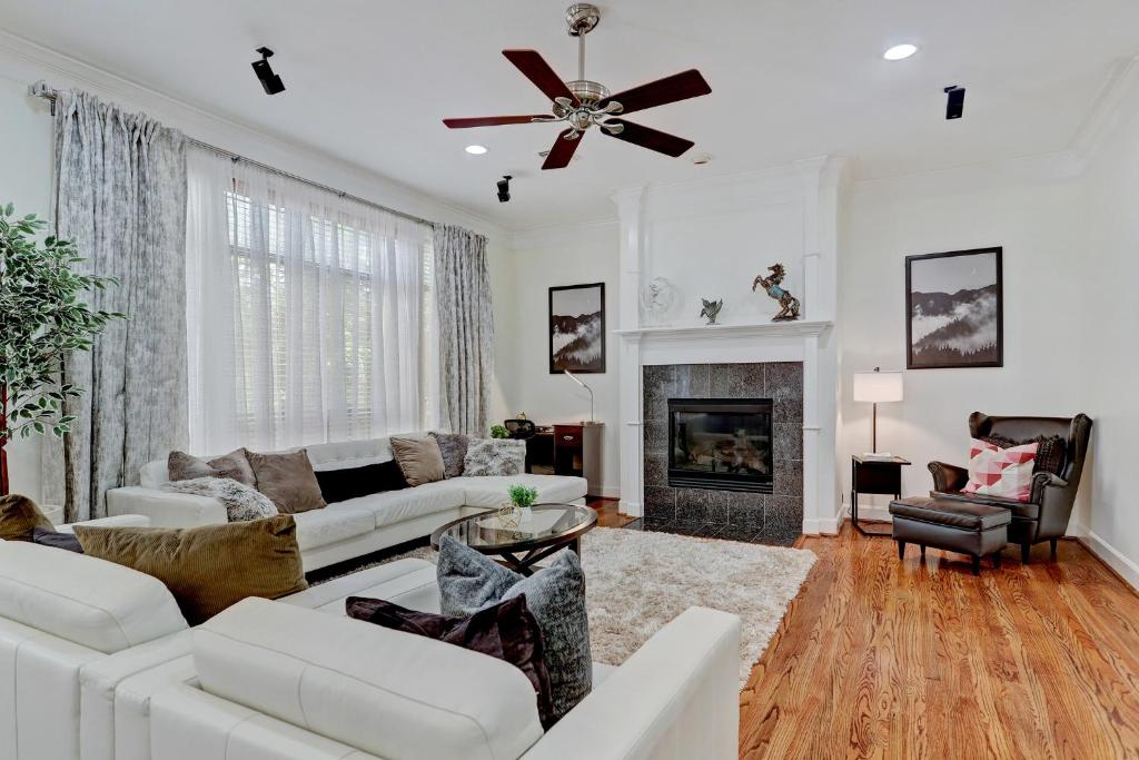 a living room with white furniture and a ceiling fan at Luxury Home Minutes to Downtown Close to Everything Nice in Houston