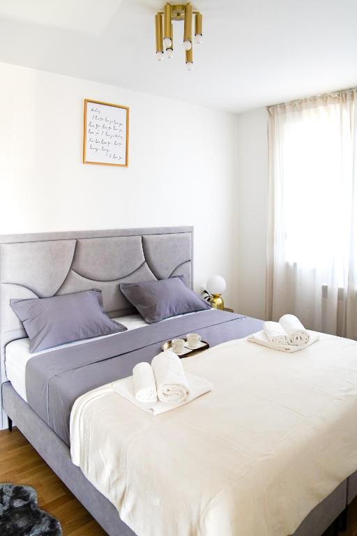 a bedroom with a large bed with towels on it at Apartment Stefani Zadar - Balcony & Free Private Garage Parking in Zadar