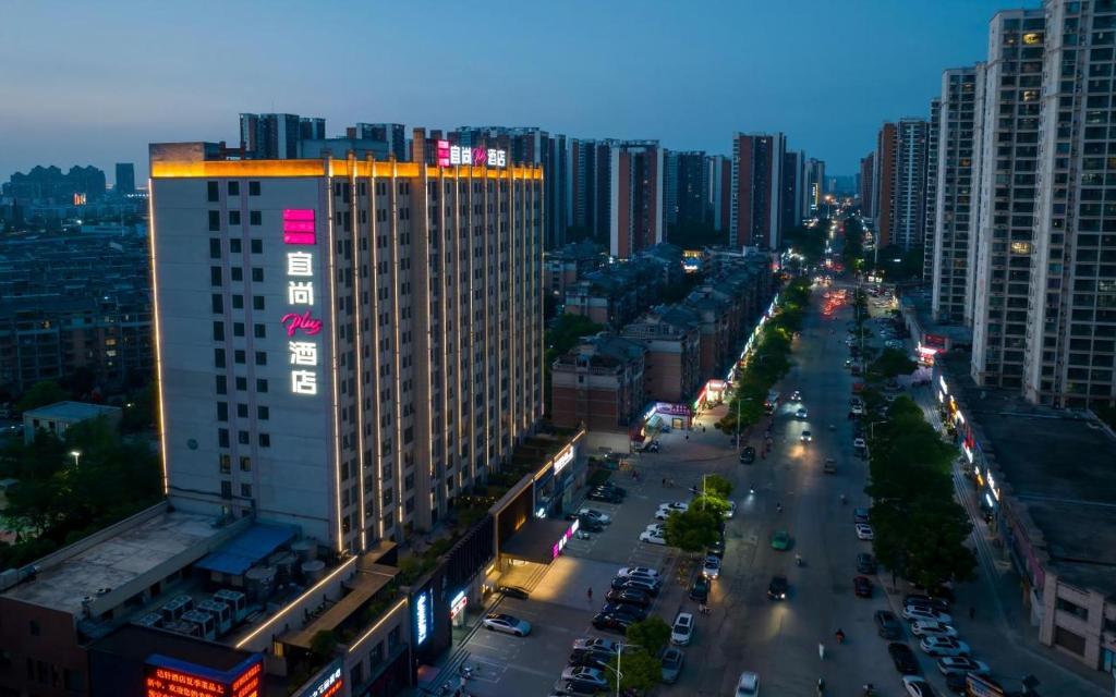 襄陽市にあるXiangyang Station Minfa World City Yishang Plus Hotelの高層ビルのある夜の街道