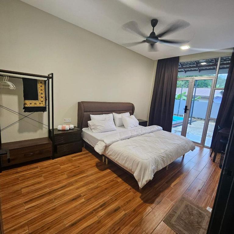 a bedroom with a bed and a ceiling fan at Sastred villa Mus'lim Only in Sungai Petani