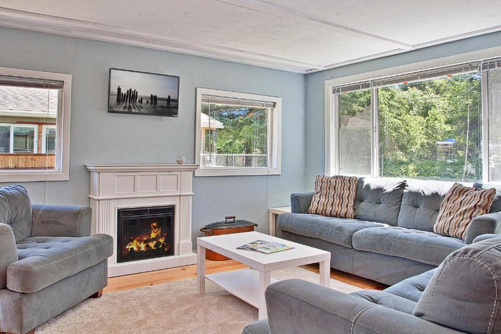ein Wohnzimmer mit zwei Sofas und einem Kamin in der Unterkunft Ten Pines Cottage in Ocean Shores