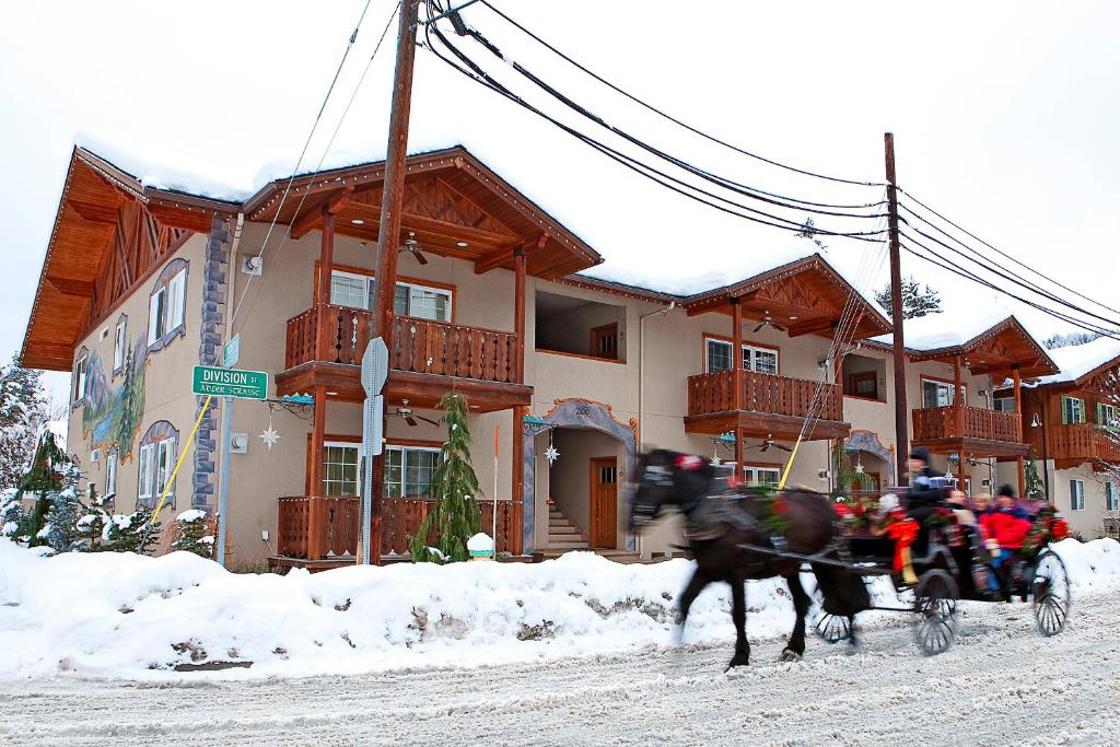 a group of people riding a horse drawn carriage in front of a house at Harlin Haus in Leavenworth