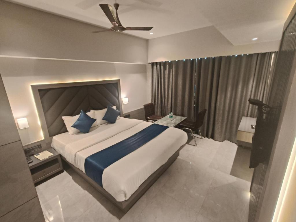 a bedroom with a large bed and a ceiling fan at Hotel Nakshtra Residency Kalyan - Premium Couple Friendly in Kalyan
