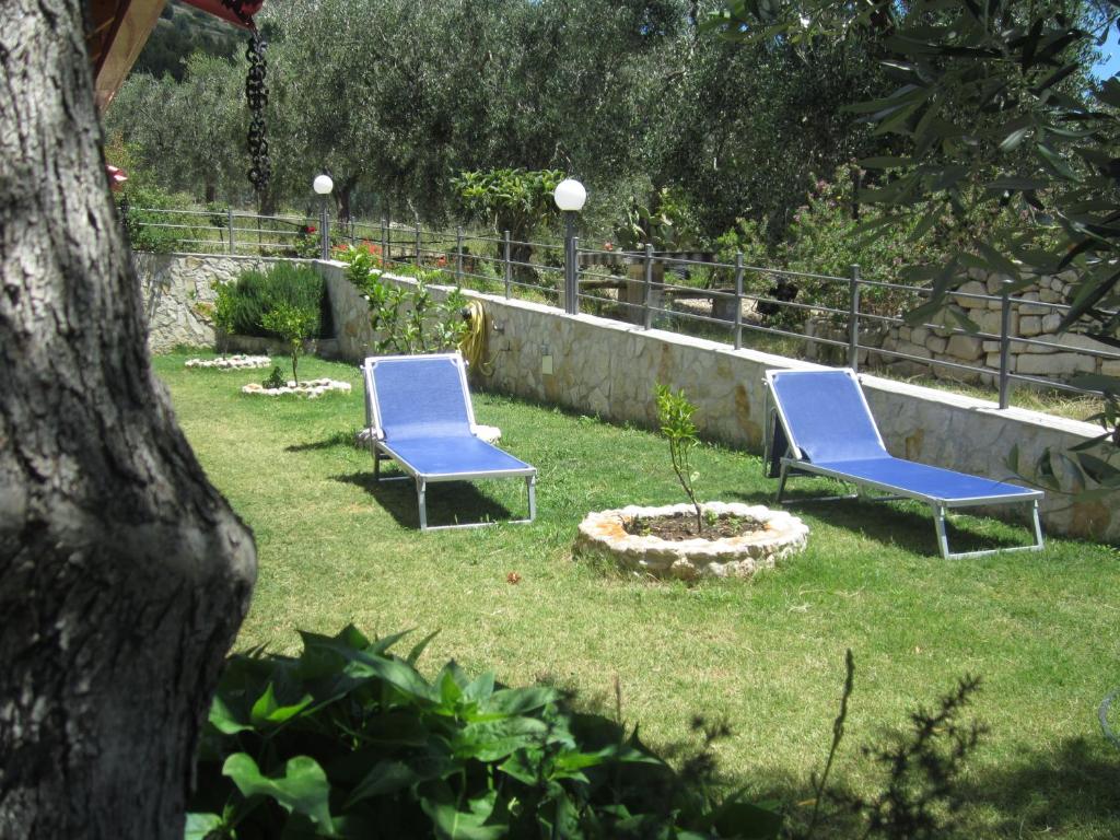 two blue chairs sitting in the grass in a yard at B&B Tor Di Lupo in Mattinata