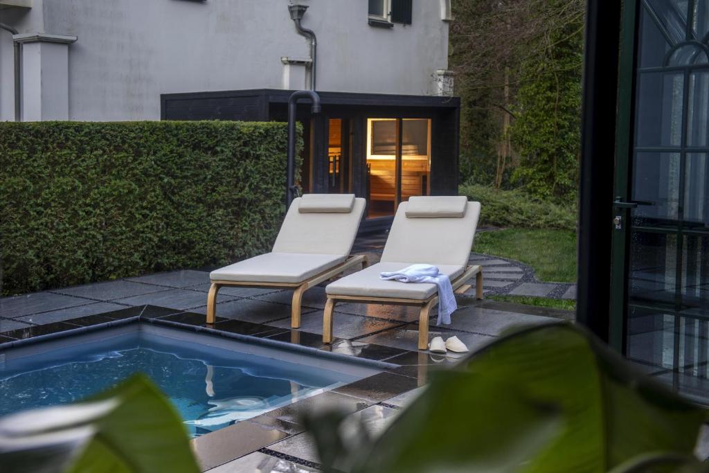 twee stoelen en een zwembad in de achtertuin bij Kasteel Engelenburg in Brummen