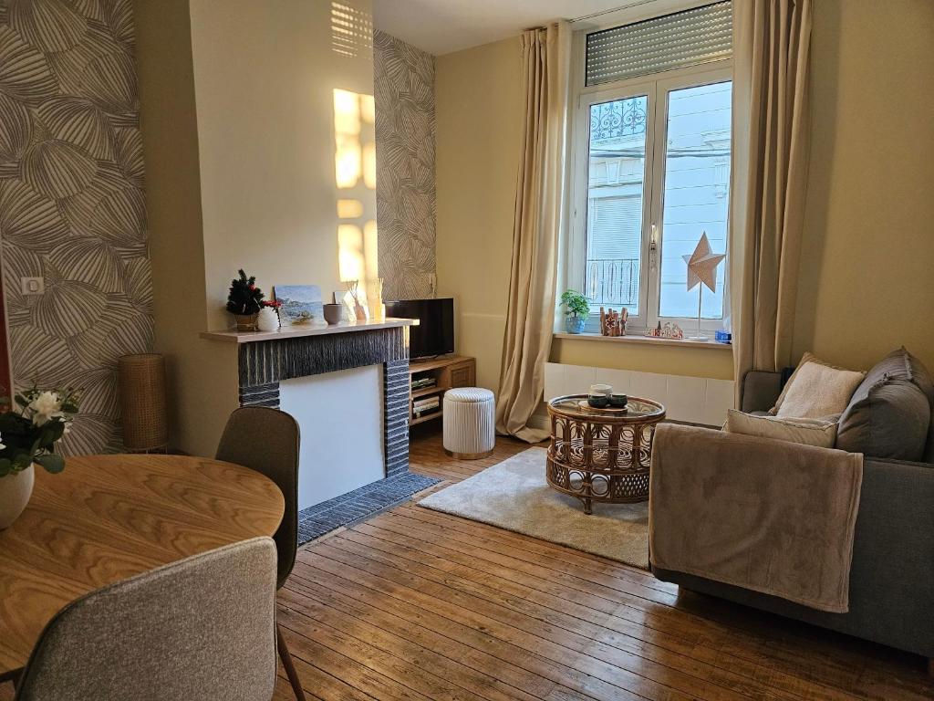un salon avec une cheminée et une table dans l'établissement La Goéliane - Appartement 2 chambres proche mer, à Wimereux