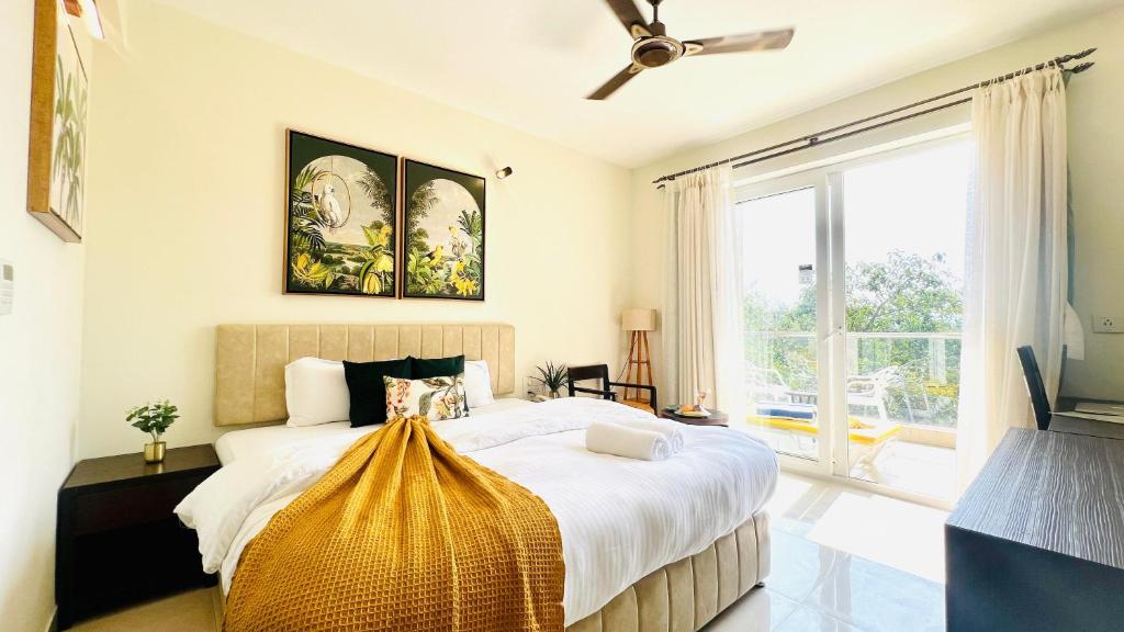 una camera con un grande letto e una grande finestra di BluO Amani Vagator - Boutique Hotel Goa ad Anjuna