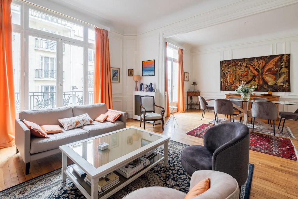 un salon avec un canapé et une table dans l'établissement Veeve - Peachy Butterflies, à Paris