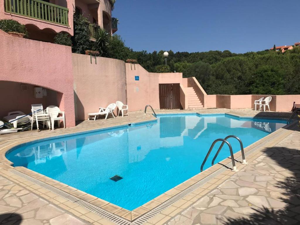 ein großes Schwimmbad mit Stühlen und einem Gebäude in der Unterkunft Elsa & David in Collioure