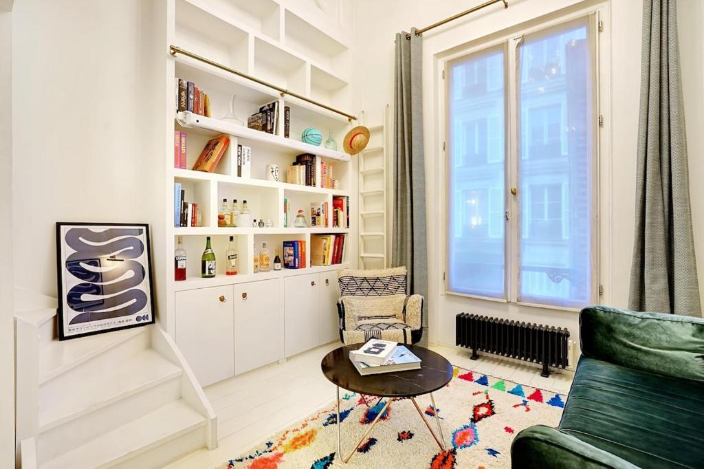 un salon avec un canapé vert et une table dans l'établissement Appartement Montmartre, à Paris