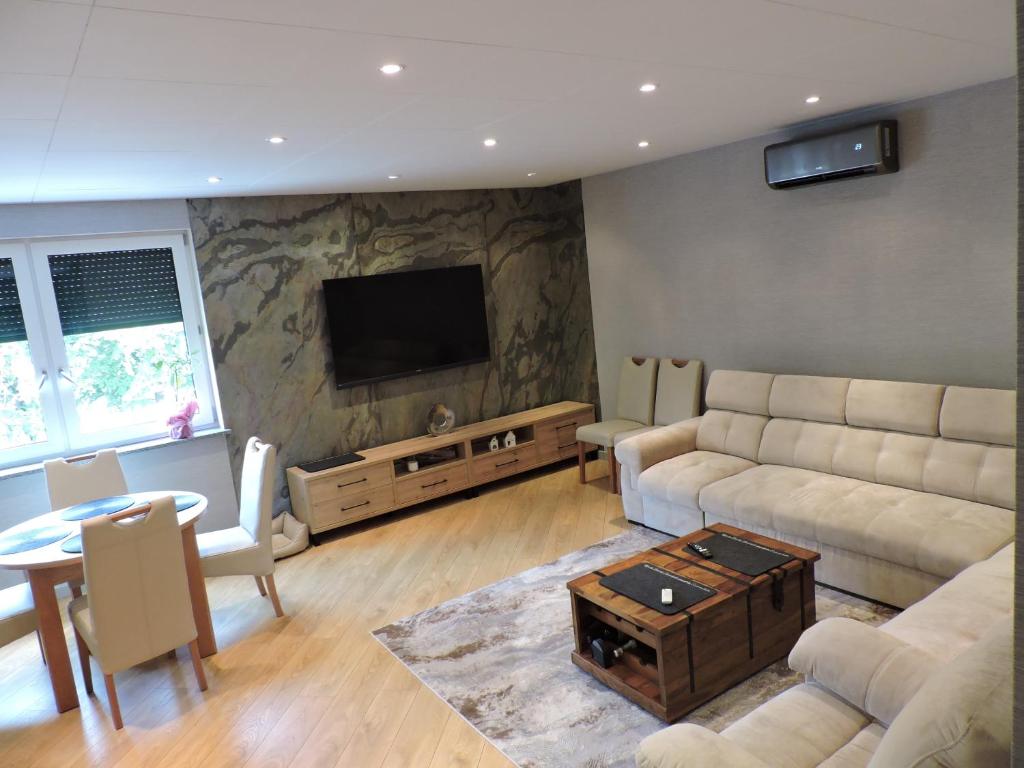 a living room with a couch and a flat screen tv at Centro Residence in Kluczbork