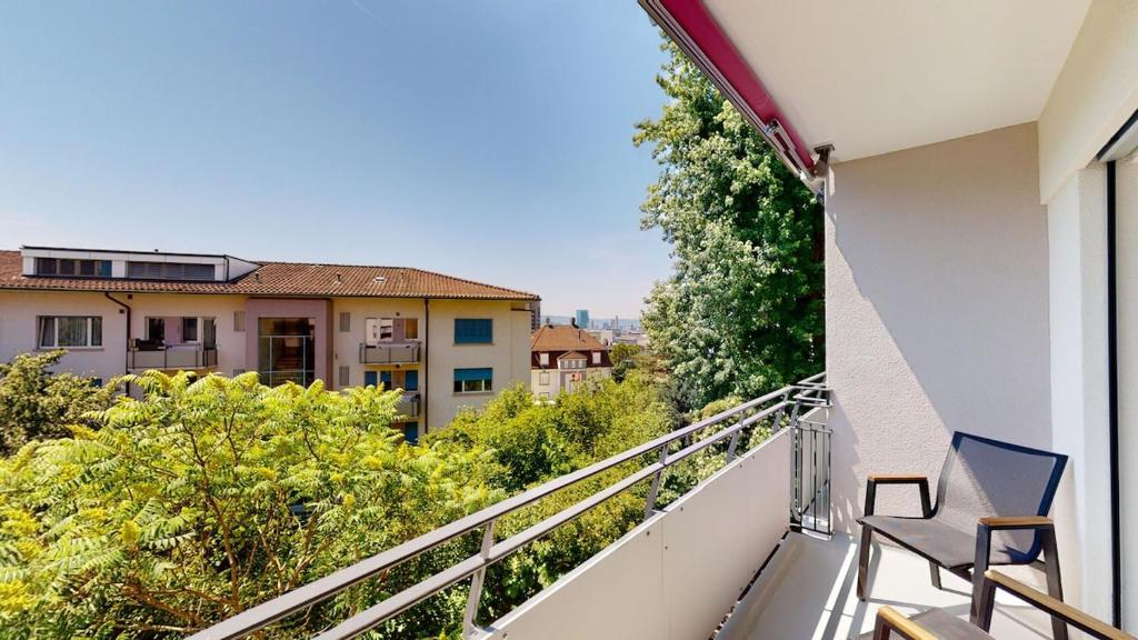 balcón con silla y vistas a la ciudad en Amazing big studio in the city center - Sun 7, en Zúrich