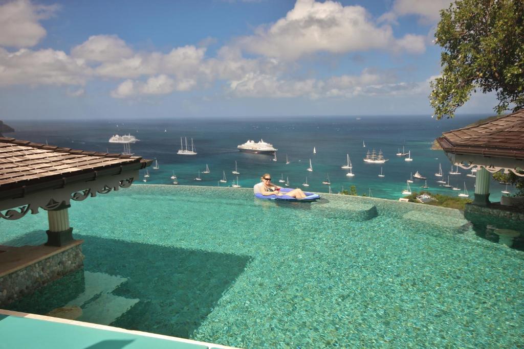 a man in a boat in a pool with a view of the ocean at Tropical Hideaway in Port Elizabeth