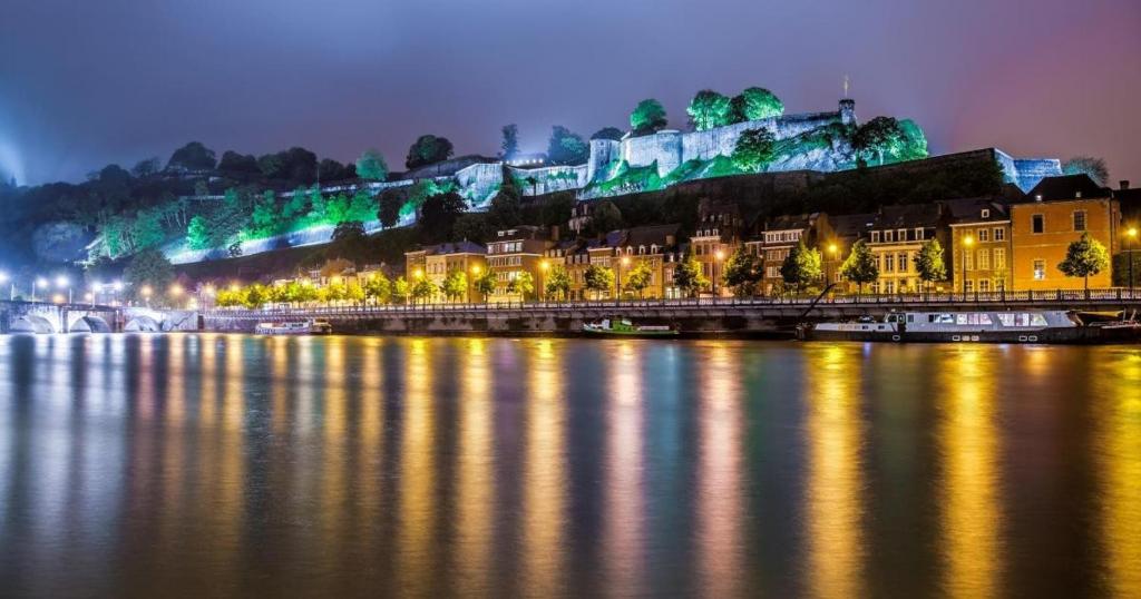 ナミュールにあるNamur, au pied de la citadelleの夜の水の隣の街