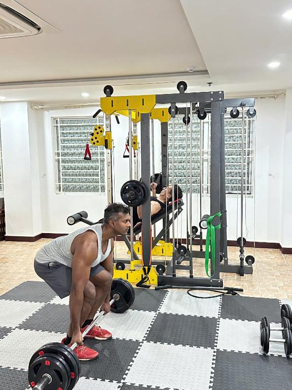 a woman squats in a gym with weights at Star Hotel and Spa Danang in Danang