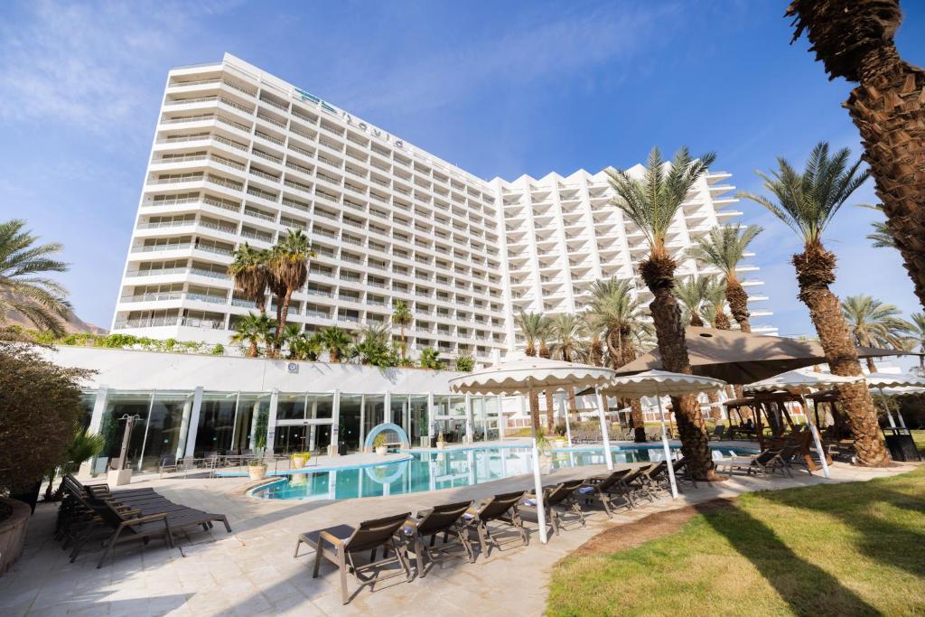 un grande hotel con piscina e palme di David Dead Sea Resort & Spa a Ein Bokek