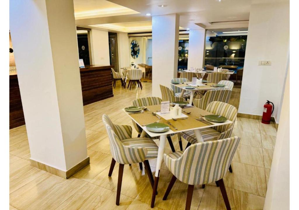 un ristorante con tavoli e sedie in una stanza di BluO Amani Vagator - Boutique Hotel Goa ad Anjuna