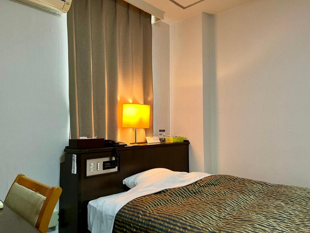 Postel nebo postele na pokoji v ubytování Nakamura Daiichi Hotel