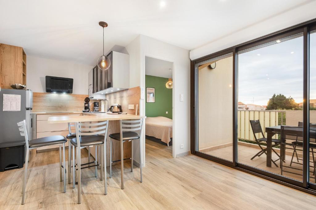 une cuisine et une salle à manger avec une table et des chaises dans l'établissement Port Lano - Joli T3 à Agde, au Cap d'Agde