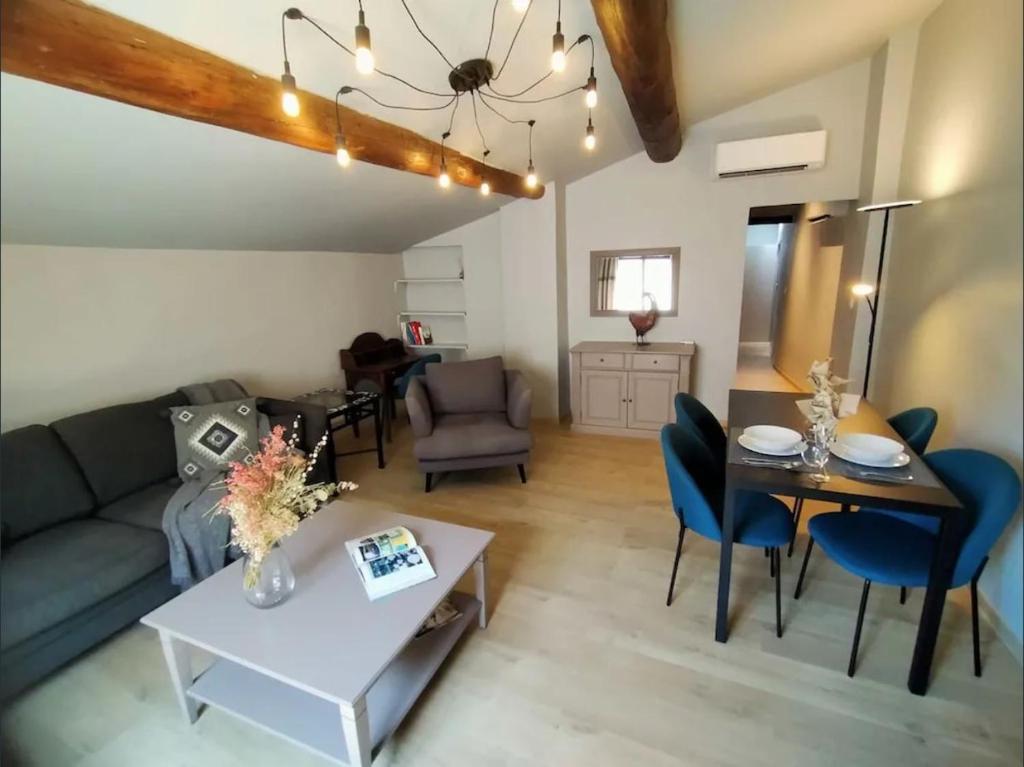 un salon avec un canapé et une table dans l'établissement Appartement duplex centre historique avec patio, à LʼIsle-sur-la-Sorgue