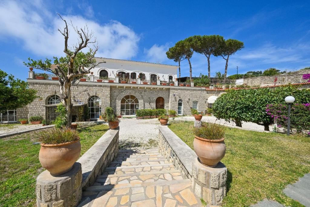 a stone building with potted plants on pillars at Tenuta Villa Tara in Ischia