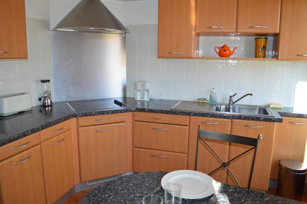 - une cuisine avec des placards en bois, un évier et un comptoir dans l'établissement Appart 2 pièces 4 couchages BANYULS SUR MER BN140-043, à Banyuls-sur-Mer