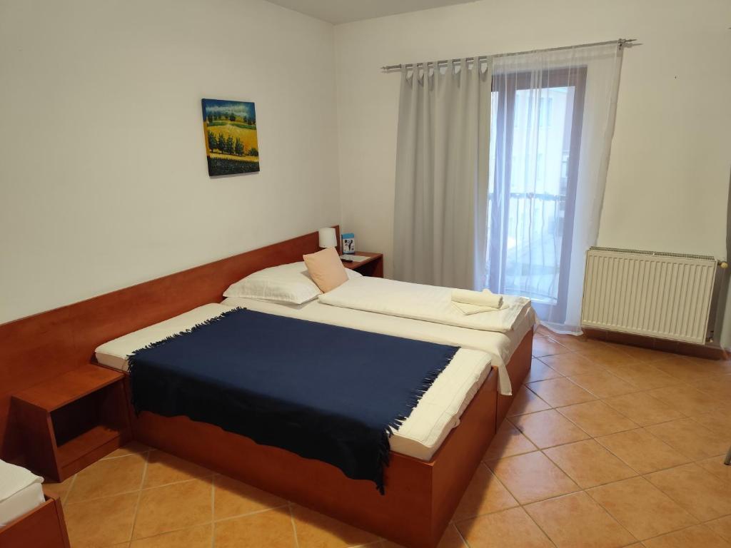 Postel nebo postele na pokoji v ubytování Szent Kristóf Apartmanhotel