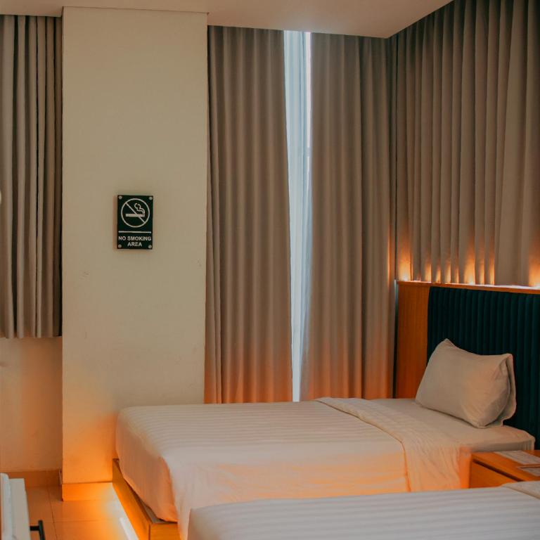 Een bed of bedden in een kamer bij The Risman Hotel At Jakarta Airport CBC