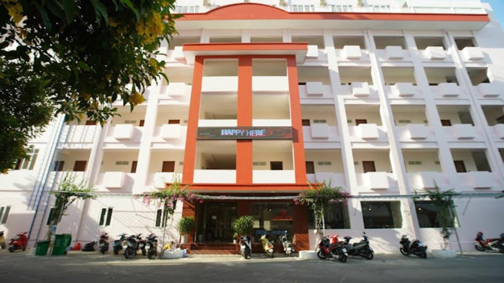 Un gran edificio con motocicletas estacionadas frente a él. en Happy Hotel Here, en Nha Trang
