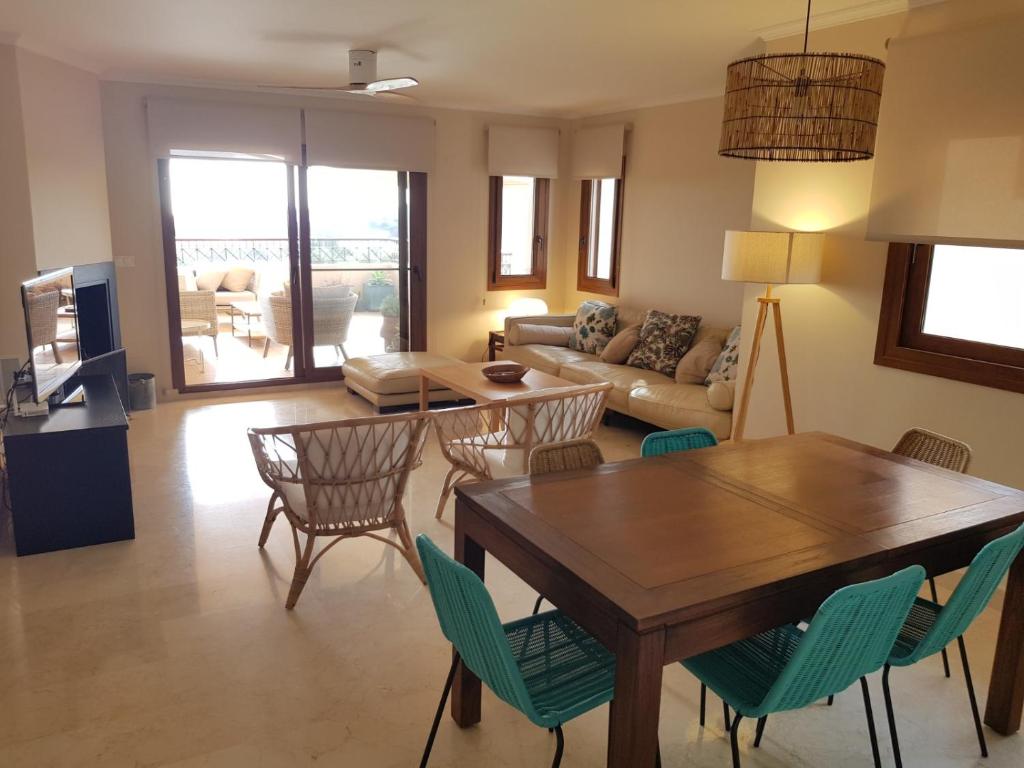 a living room with a table and chairs at Apartamento duplex en resort de golf y playa in Atamaría
