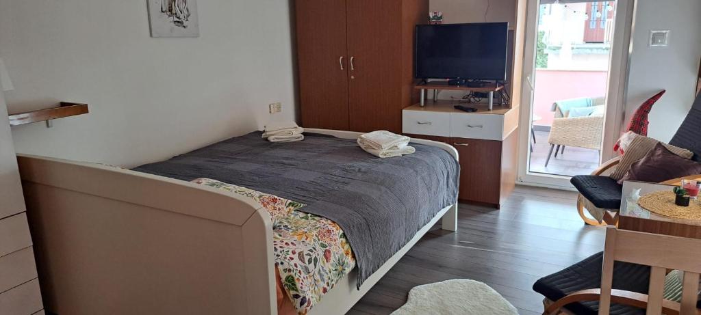 a bedroom with a bed and a living room with a tv at Srce Turopolja in Velika Gorica