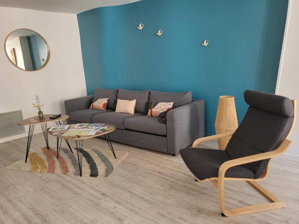 un salon avec un canapé et une chaise dans l'établissement Appartement hypercentre Fontainebleau, à Fontainebleau