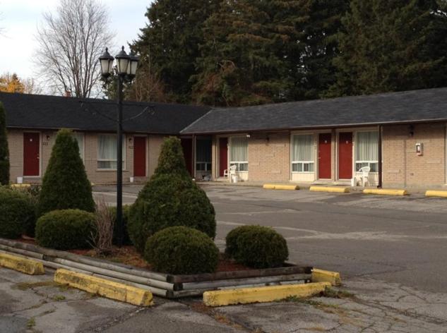 een gebouw met een straatlicht op een parkeerplaats bij Lotus Motel in Cobourg