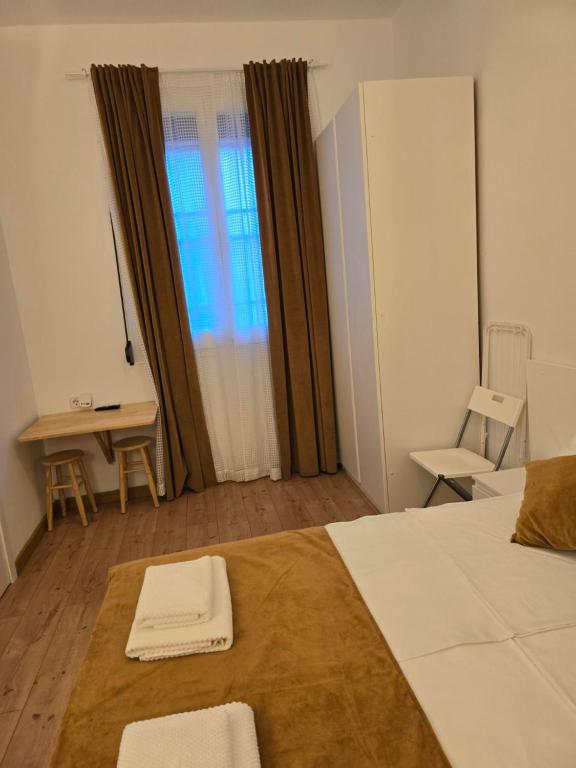 a bedroom with a bed and a desk and a window at Casa Acogedora in Hospitalet de Llobregat