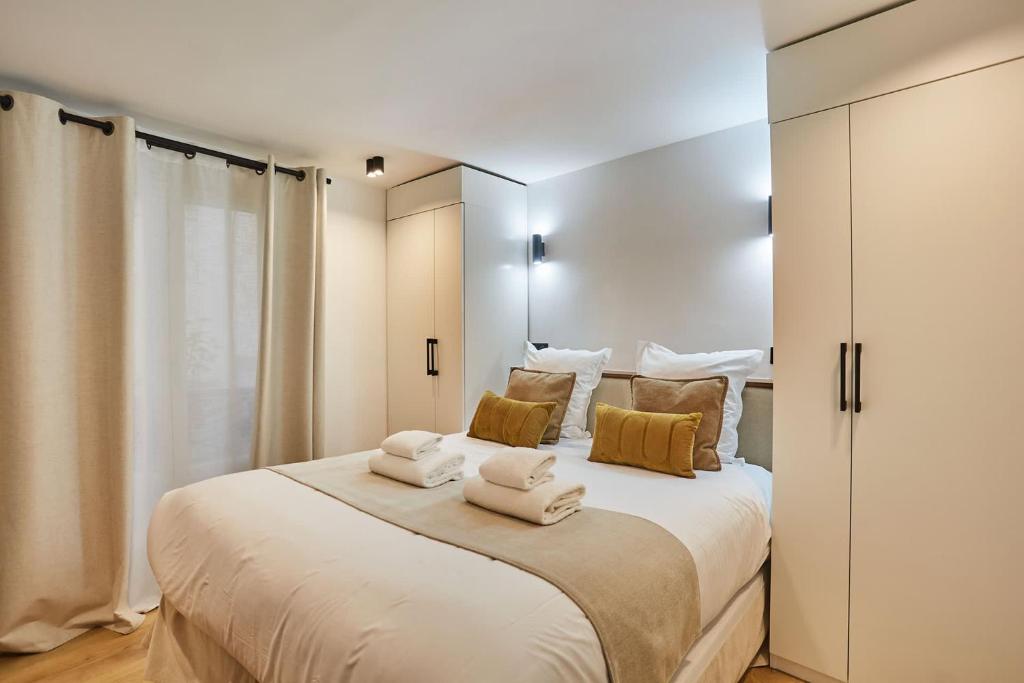 une chambre avec un grand lit avec des serviettes dessus dans l'établissement Superb Apartment Center of Paris by Studio prestige, à Paris
