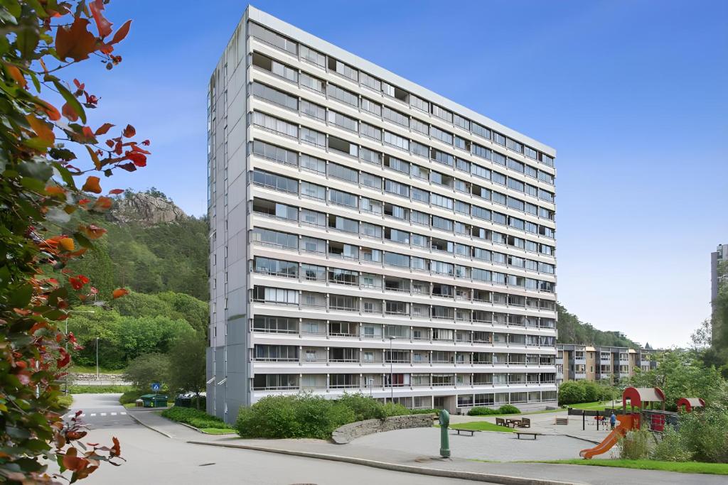 ベルゲンにあるCute apartment in high riseのたくさんの窓がある背の高い白い建物