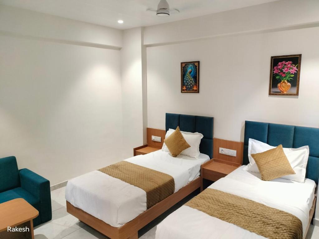 瓦皮Hotel Royal Park的一间有两张床和一把蓝色椅子的酒店房间