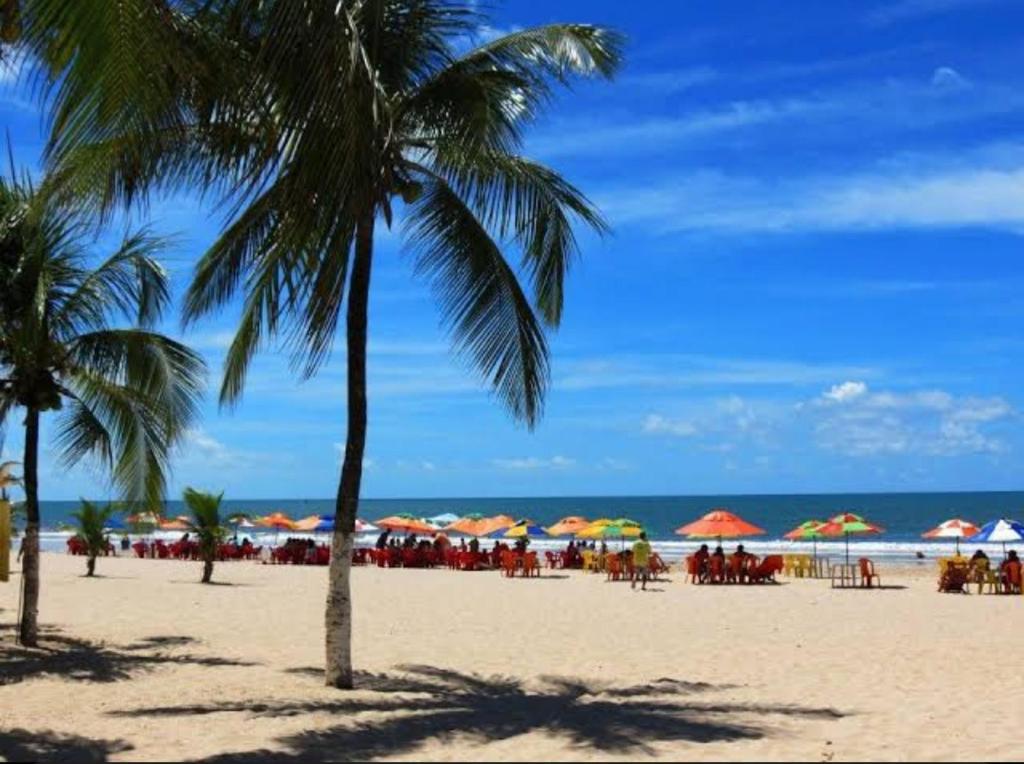 a beach with chairs and umbrellas and the ocean at Casa de Praia - temporada in Valença