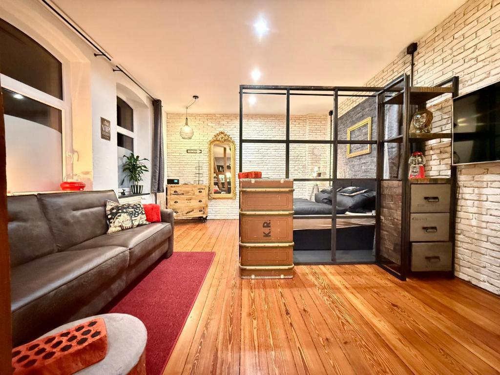 a living room with a couch and a bedroom at Femo Ziegelei - tiny Loft - separater Eingang - Parkplatz in Burbach