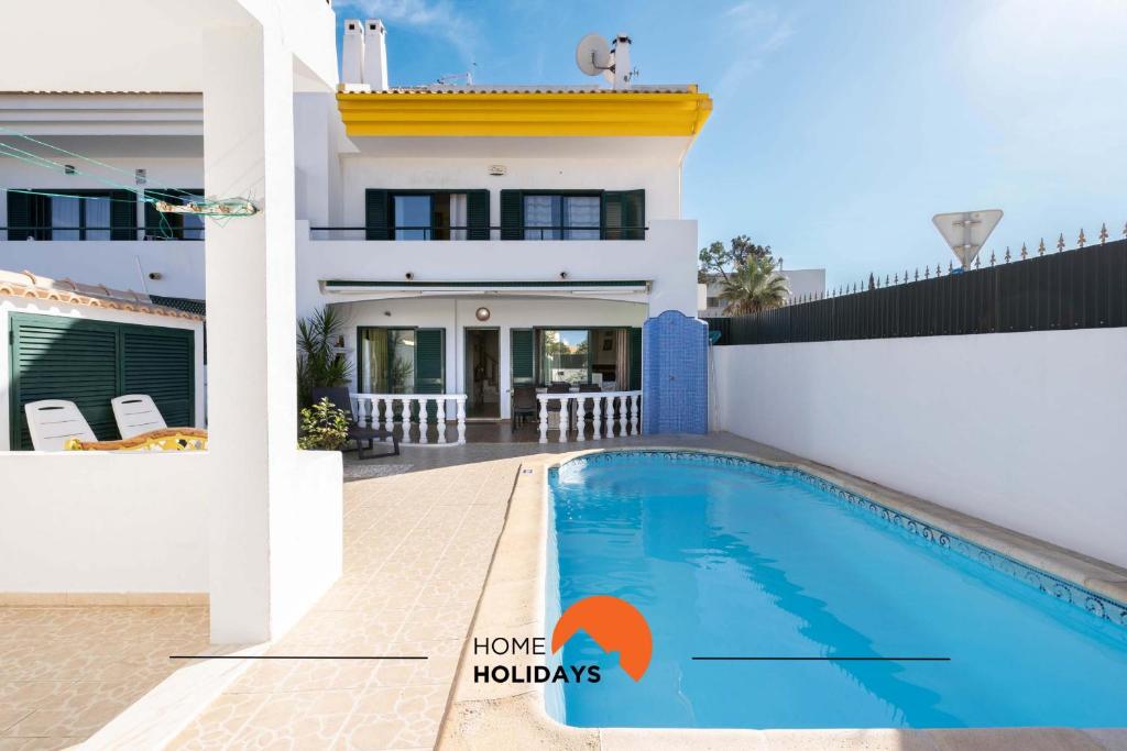 a villa with a swimming pool in front of a house at #039 Family Private Pool AC in Vale de Pedras