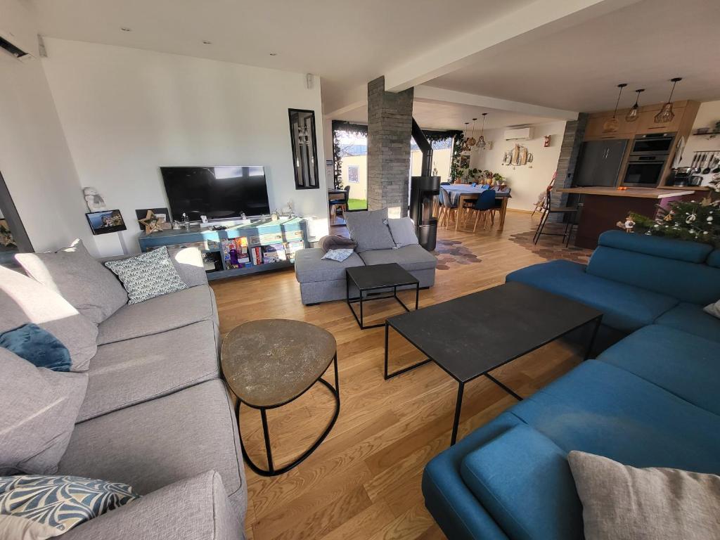 un salon avec des canapés bleus et une cuisine dans l'établissement Maison proche Paris et Stade de France, à Saint-Denis