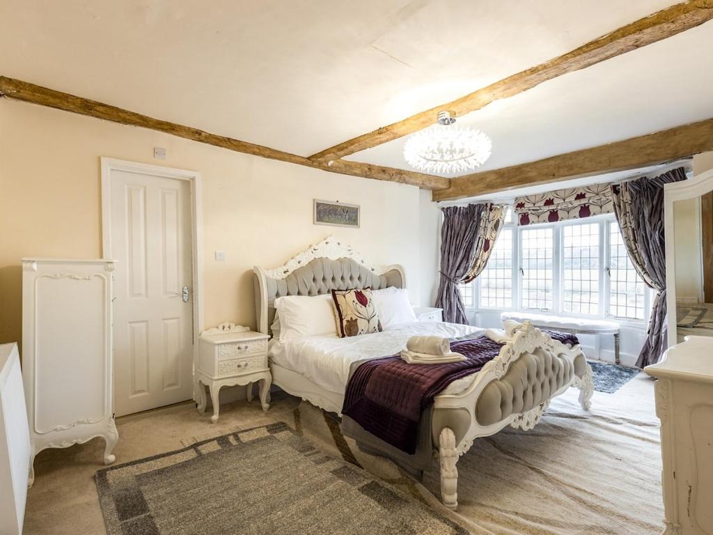 a bedroom with a white bed and a window at Riverside Manor in Offenham